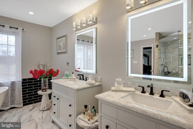 full bathroom with marble finish floor, two vanities, a sink, and a shower stall