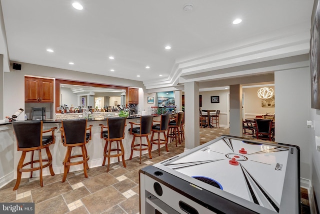 game room featuring indoor bar, stone finish floor, and recessed lighting