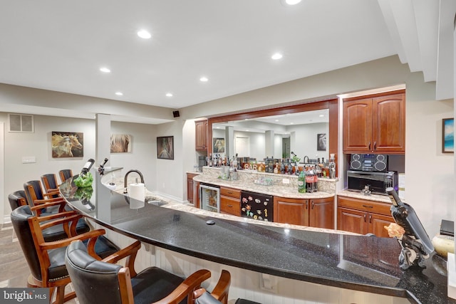 kitchen with beverage cooler, recessed lighting, visible vents, and a kitchen breakfast bar