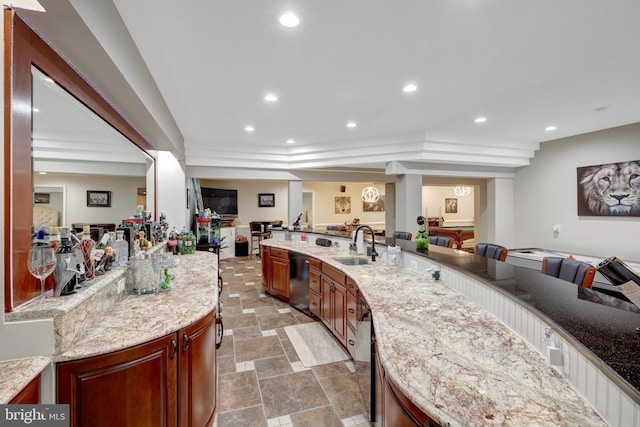 kitchen with dishwasher, stone finish floor, open floor plan, a sink, and recessed lighting