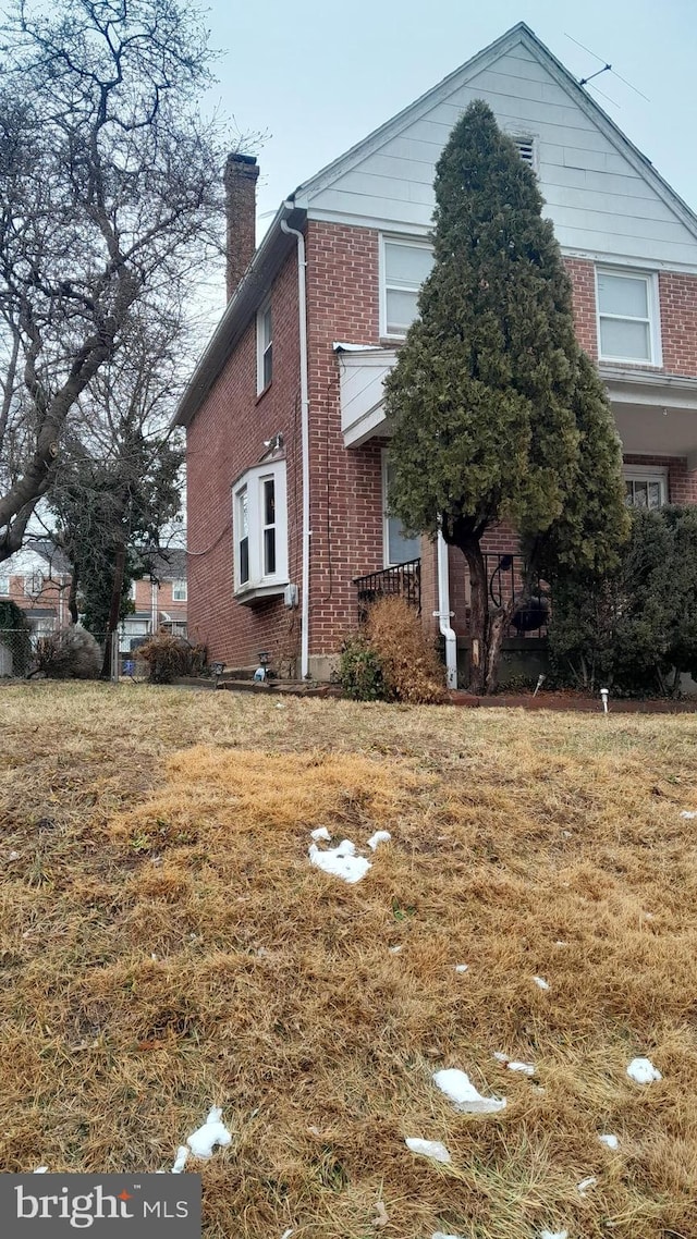 1628 Gleneagle Rd, Baltimore, MD 21239 - view of front of home featuring brick siding, a chimney, and a front yard