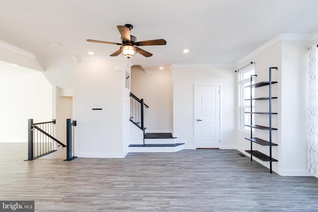 interior space featuring crown molding, wood-type flooring, and ceiling fan