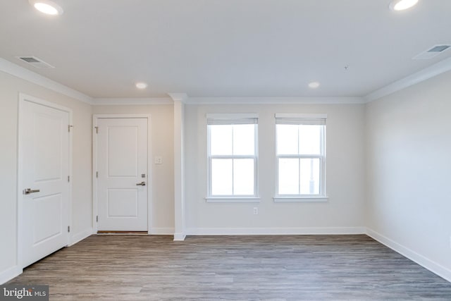 spare room with crown molding and light wood-type flooring