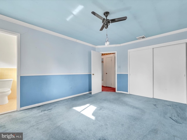 unfurnished bedroom with ceiling fan, carpet, connected bathroom, ornamental molding, and a closet