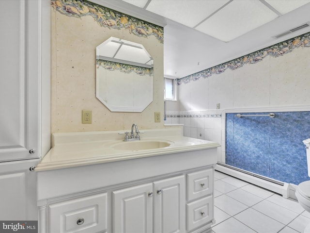 bathroom featuring tile walls, a baseboard heating unit, vanity, tile patterned floors, and toilet