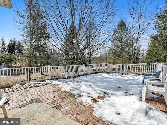 snow covered deck with a patio area