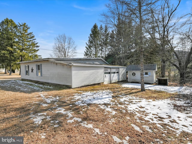 view of snow covered exterior with a shed