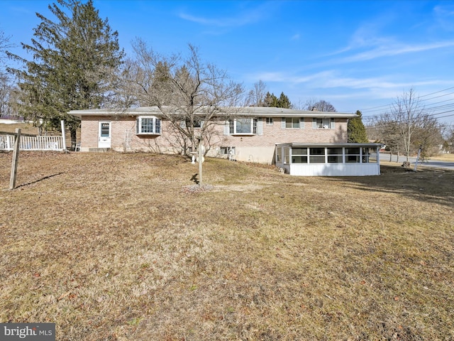 view of front of home featuring a sunroom and a front lawn