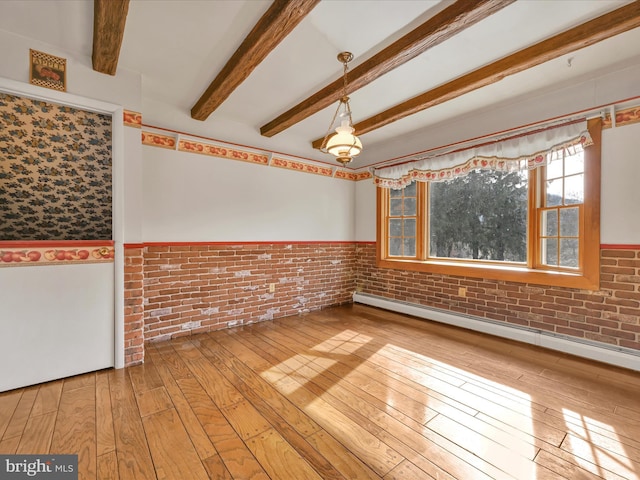 spare room featuring hardwood / wood-style flooring, brick wall, a baseboard heating unit, and beamed ceiling