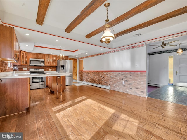 kitchen featuring a center island, hanging light fixtures, light wood-type flooring, a baseboard radiator, and appliances with stainless steel finishes