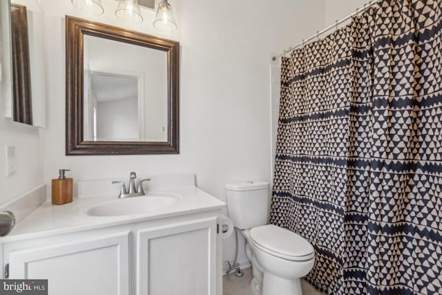 bathroom featuring vanity, walk in shower, and toilet