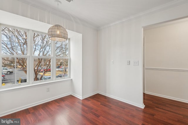 spare room featuring ornamental molding, a healthy amount of sunlight, and dark hardwood / wood-style floors