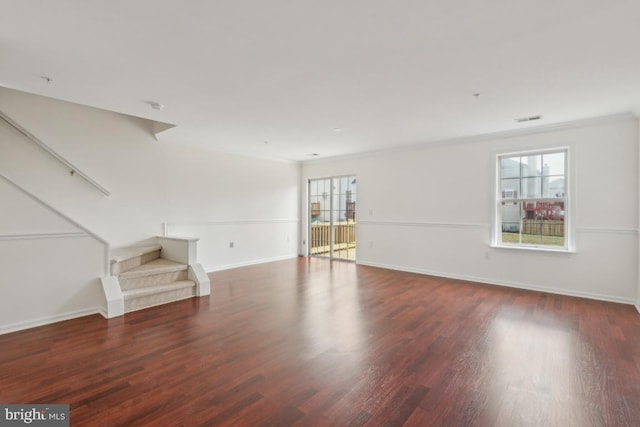 unfurnished living room featuring ornamental molding and dark hardwood / wood-style floors