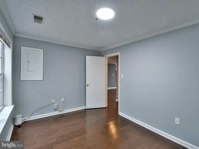 unfurnished room with dark wood-type flooring, ornamental molding, a textured ceiling, and electric panel