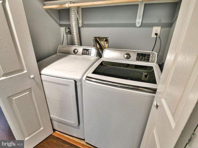 washroom featuring washing machine and clothes dryer and dark hardwood / wood-style flooring