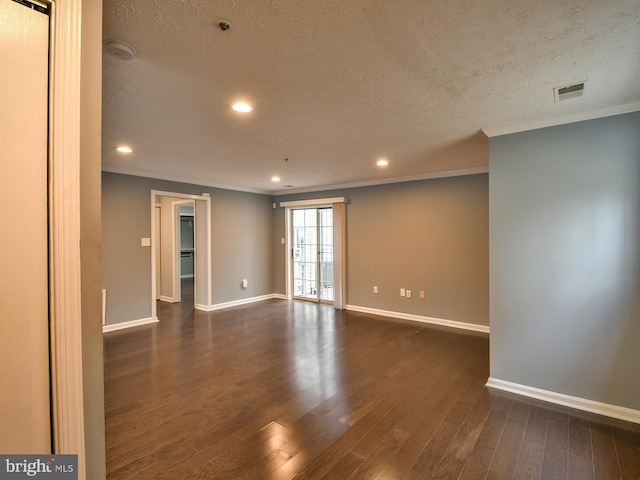 empty room featuring crown molding, dark wood-type flooring, and a textured ceiling