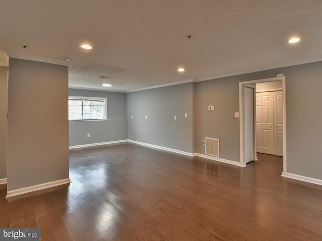 spare room with crown molding and dark hardwood / wood-style floors