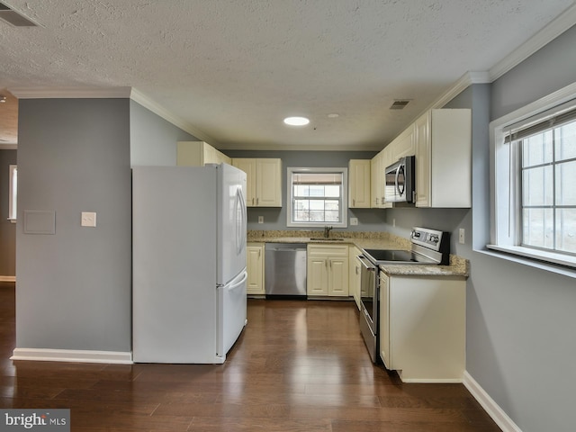 kitchen featuring sink, crown molding, a textured ceiling, dark hardwood / wood-style flooring, and stainless steel appliances