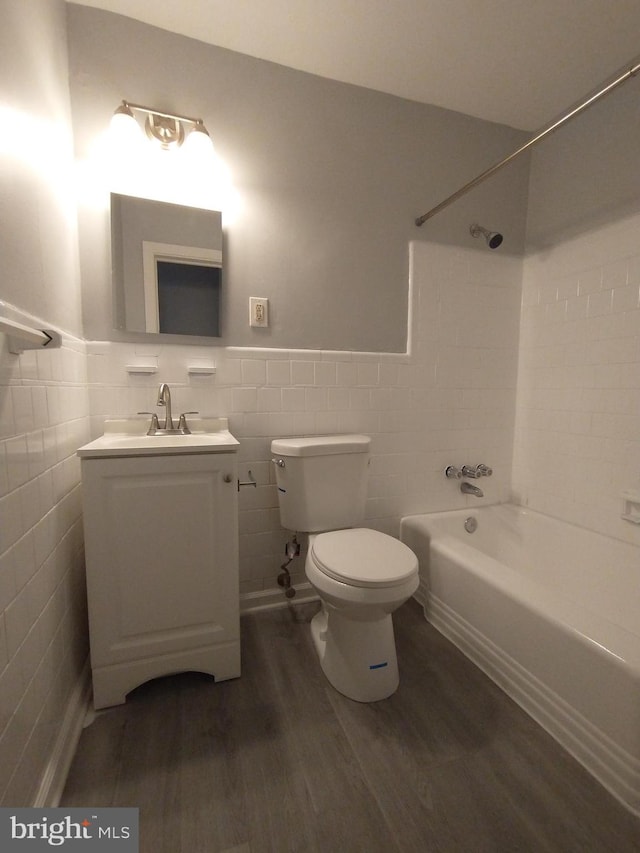 full bathroom with hardwood / wood-style flooring, vanity, tile walls, and toilet