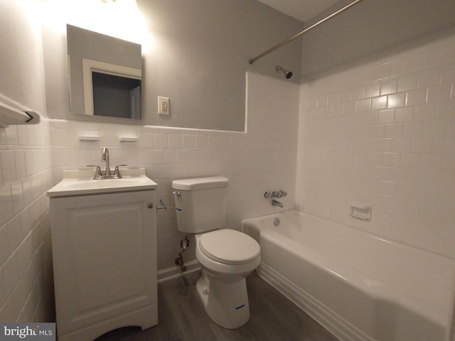 full bathroom featuring toilet, tile walls, vanity, tiled shower / bath combo, and hardwood / wood-style floors