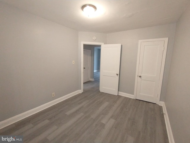 unfurnished room with dark wood-type flooring