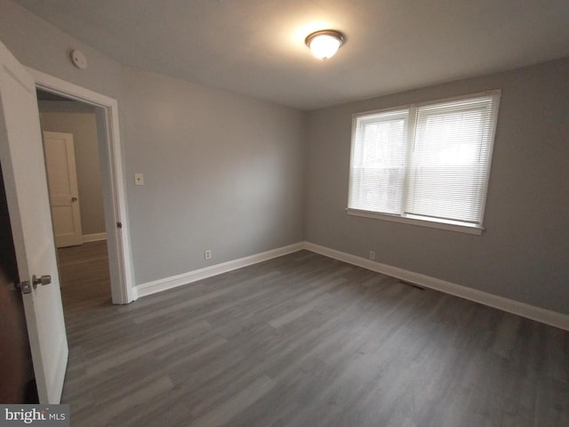 unfurnished room featuring dark wood-type flooring