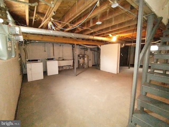 basement with water heater, sink, and washer and dryer