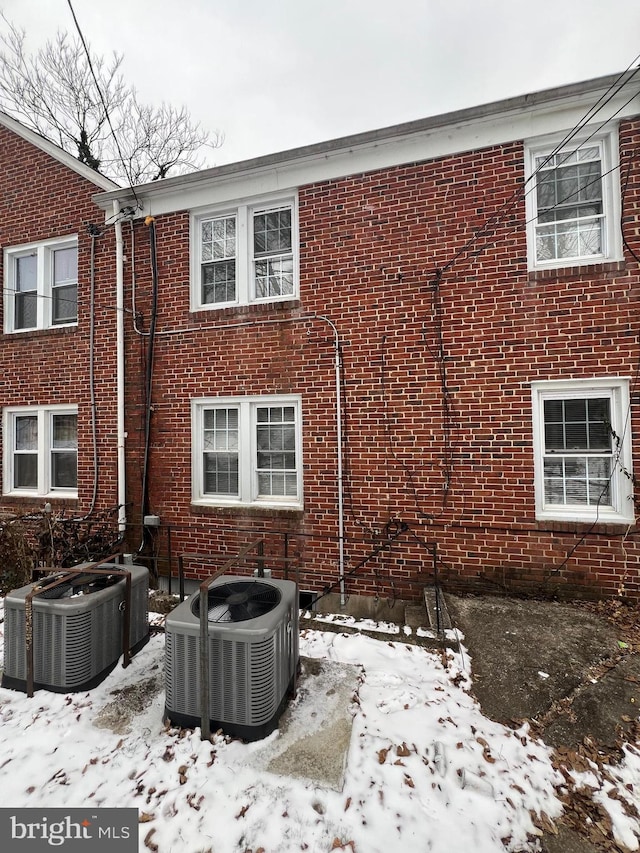 snow covered back of property with central air condition unit