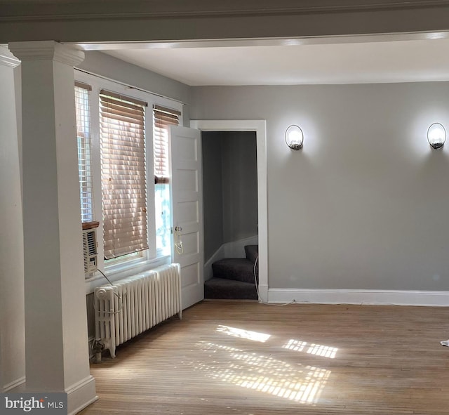 3800 40th Ave, Brentwood, MD 20722 - spare room with decorative columns, radiator heating unit, and light wood-type flooring