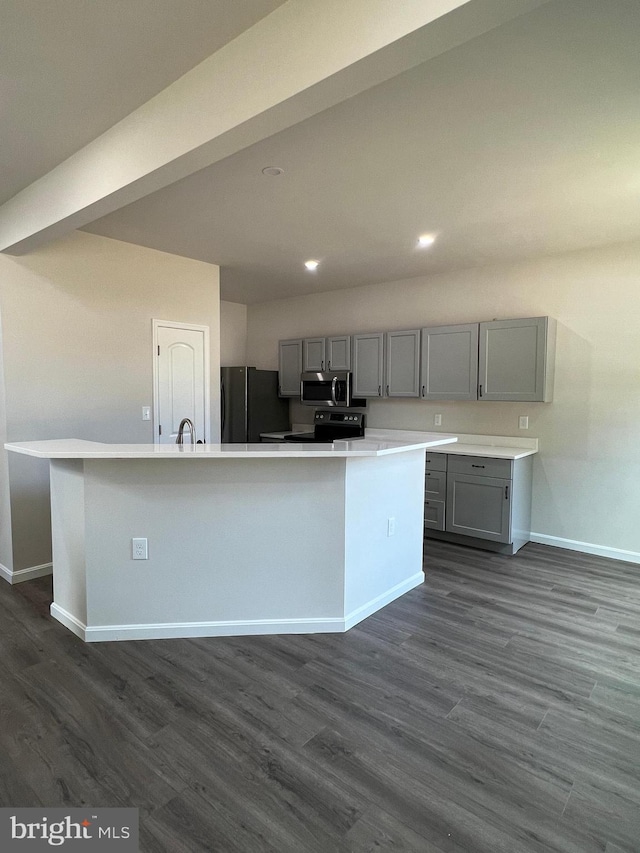 kitchen featuring black refrigerator, gray cabinets, and a center island with sink