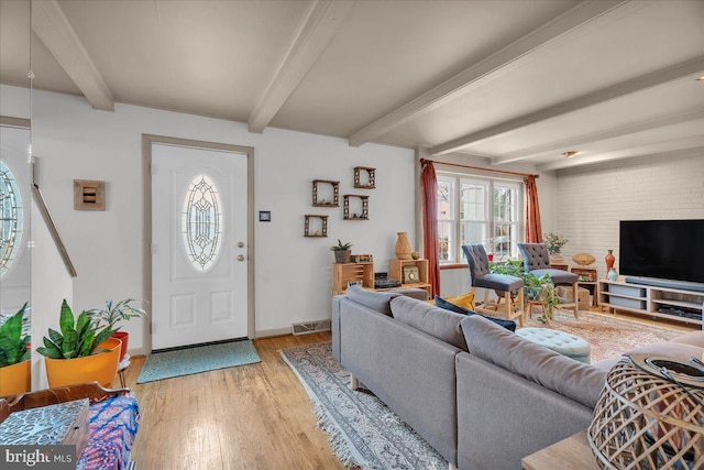 living room featuring beam ceiling and light wood-type flooring