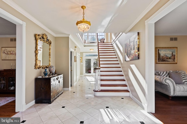 tiled entrance foyer with an inviting chandelier and ornamental molding