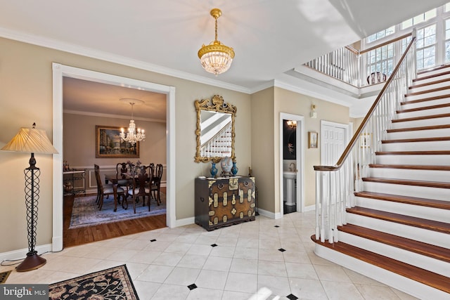 foyer entrance featuring a notable chandelier, light tile patterned floors, and ornamental molding