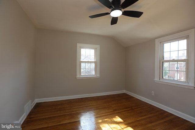 additional living space with a healthy amount of sunlight, lofted ceiling, and dark hardwood / wood-style floors