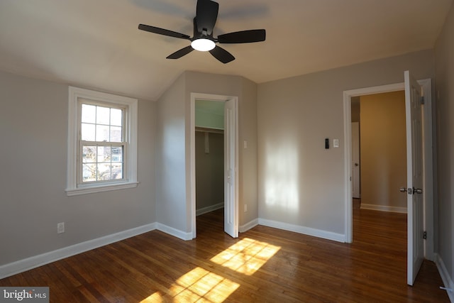 unfurnished bedroom with ceiling fan, dark hardwood / wood-style floors, a closet, and a spacious closet