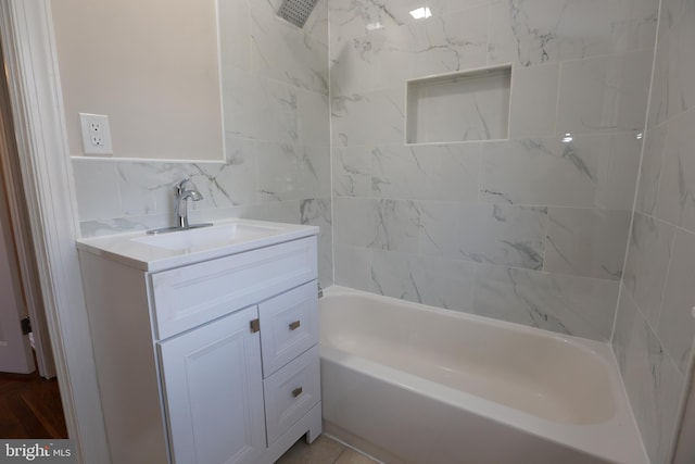 bathroom featuring vanity, tub / shower combination, and tile walls