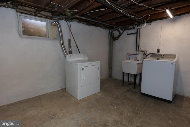 clothes washing area with washing machine and clothes dryer and sink