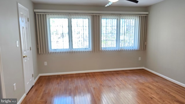 spare room featuring ceiling fan, baseboards, and wood finished floors