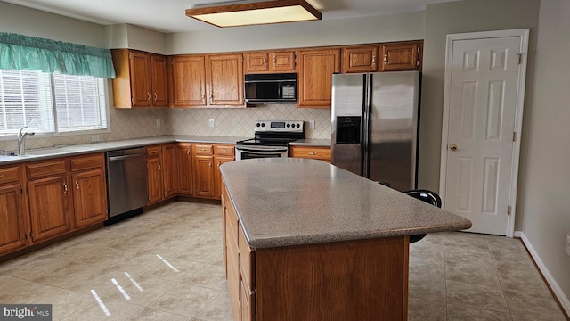 kitchen featuring a sink, appliances with stainless steel finishes, and brown cabinetry