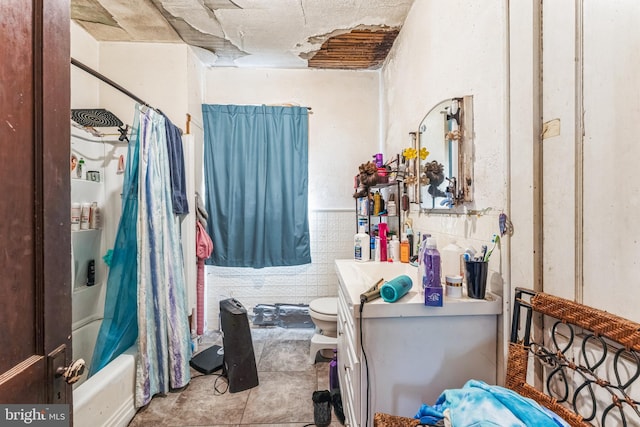 full bathroom featuring vanity, shower / tub combo, tile walls, and toilet