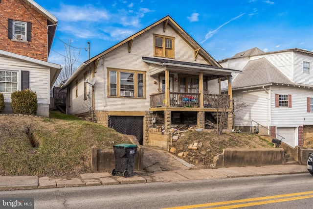 view of property with a garage, cooling unit, and covered porch