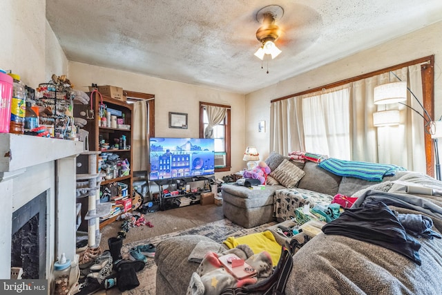 living room featuring ceiling fan and a textured ceiling