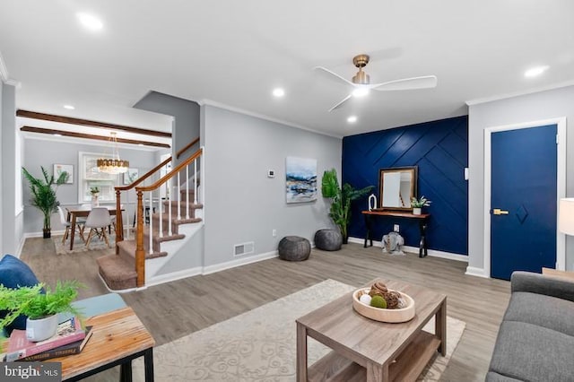 living area with recessed lighting, visible vents, light wood-style floors, ornamental molding, and baseboards