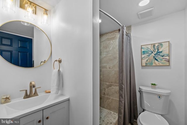 bathroom with toilet, a stall shower, visible vents, and vanity