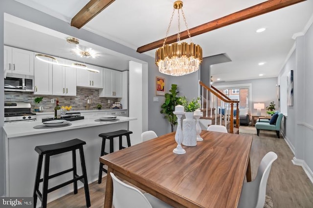 dining area with light wood-style flooring, recessed lighting, stairs, beamed ceiling, and an inviting chandelier