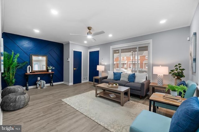 living area with baseboards, ceiling fan, an accent wall, wood finished floors, and recessed lighting