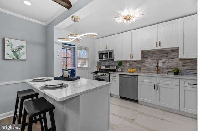 kitchen featuring decorative light fixtures, tasteful backsplash, appliances with stainless steel finishes, ornamental molding, and white cabinetry