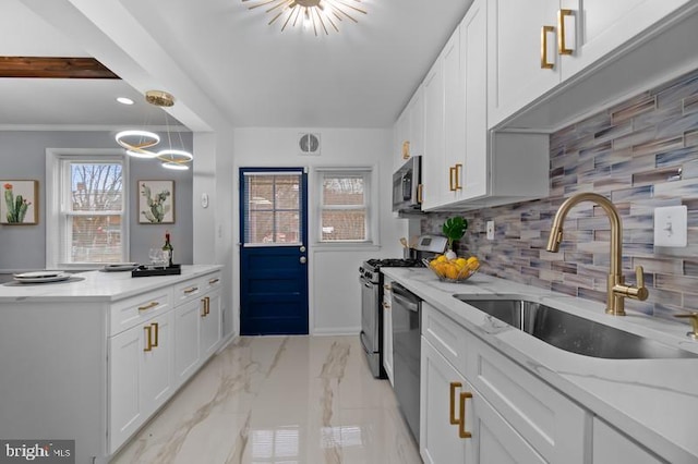 kitchen featuring stainless steel appliances, a sink, white cabinetry, and an inviting chandelier