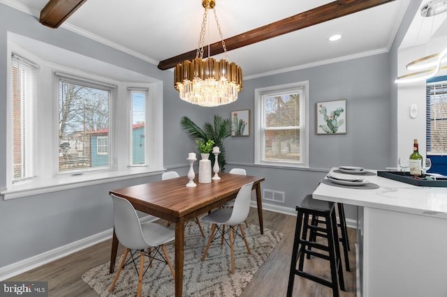 dining room with baseboards, beam ceiling, and wood finished floors