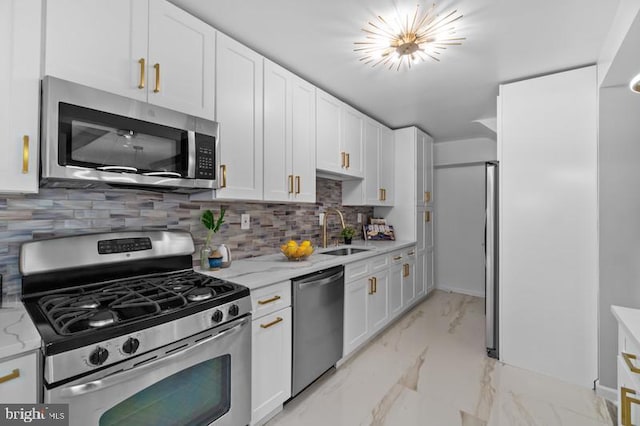 kitchen with appliances with stainless steel finishes, marble finish floor, white cabinetry, and a sink